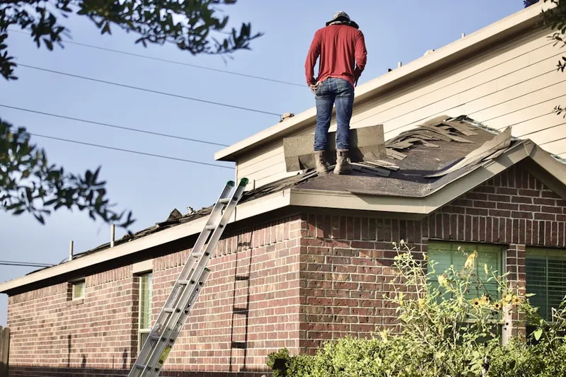Professional roofer working on a residential roof in Woodfin